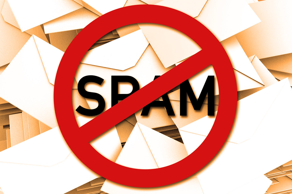 Anti-SPAM-Schild mit Mails im Hintergrund - orange